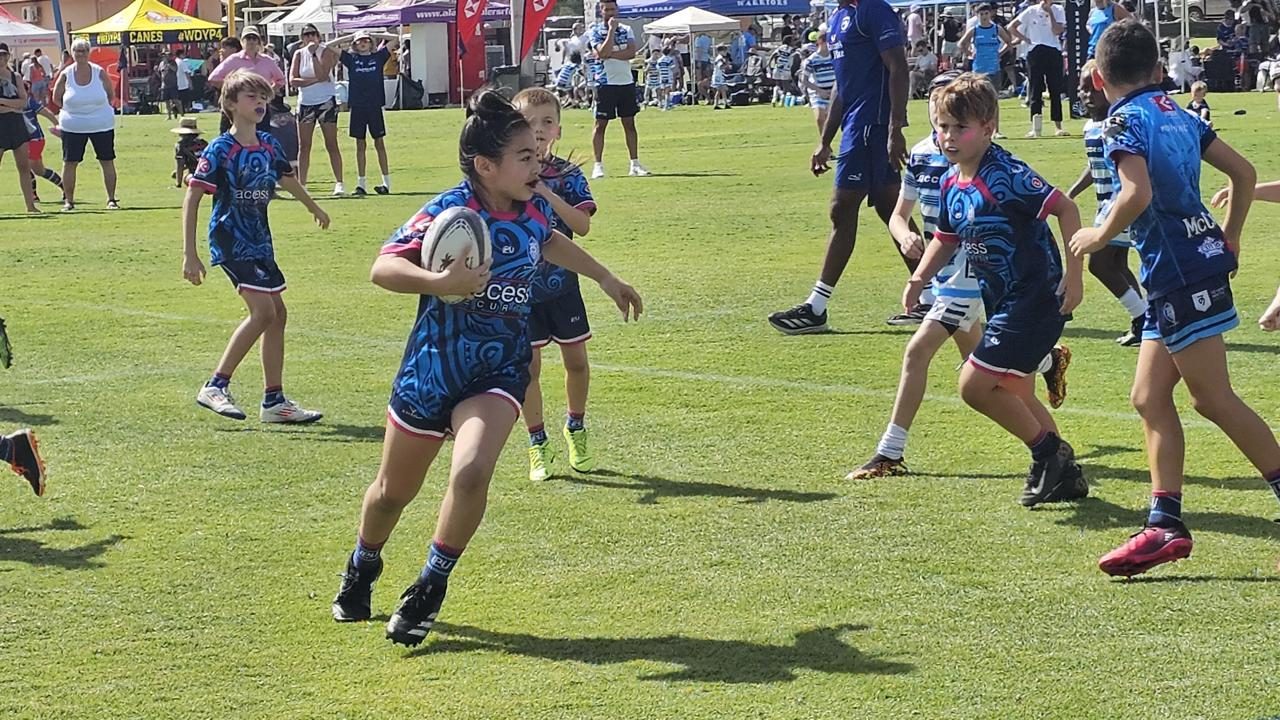 Dubai Warriors player runs with the ball in a youth rugby match